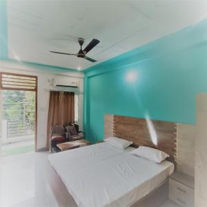a bedroom with a bed and a blue wall at Prem Home Stay in Rishīkesh