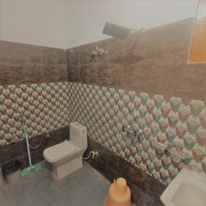 a bathroom with a toilet and a sink at Prem Home Stay in Rishīkesh