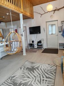 a living room with a swinging chair and a tv at Villa Repovesi in Hillosensalmi