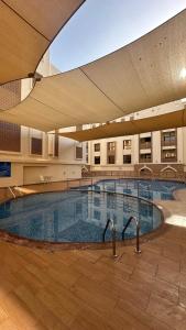 a large swimming pool inside of a building at MAZAYA B2 apartment in Mawāliḩ