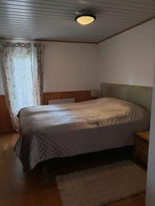 a bedroom with a large bed and a window at Villa Repovesi in Hillosensalmi