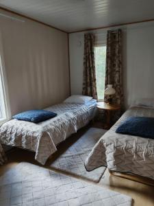 a bedroom with two beds and a window at Villa Repovesi in Hillosensalmi