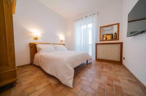 a bedroom with a white bed and a tiled floor at Domus Emma in Cantalupo in Sabina