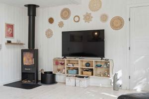 a living room with a fireplace and a stove at Charming Cottage Close To The Beach in Glesborg +10 photos
