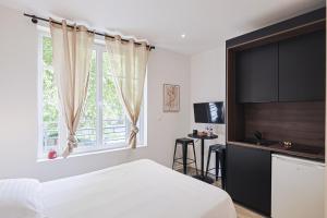 a bedroom with a bed and a tv and a window at LES BULLES DE MONA - Passion - Spa - Clim in Lyon