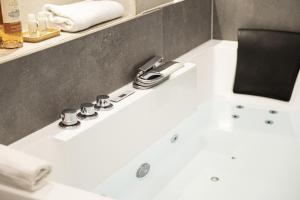 a bathroom with a white tub and a sink at LES BULLES DE MONA - Passion - Spa - Clim in Lyon