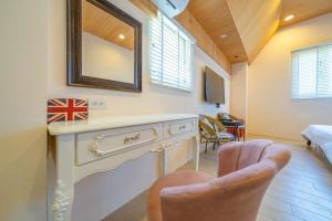 a chair in a room with a vanity and a mirror at 騎馬打仗民宿 in Yilan City