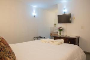 a bedroom with a bed with two towels on it at San Telmo Petit Hotel in Buenos Aires