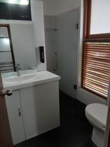 ein Badezimmer mit einem weißen Waschbecken und einer Toilette in der Unterkunft A Wood's View Villa in Kandy + 23 Fotos
