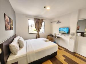 Una televisión o centro de entretenimiento en The Ardens Hotel - Taman Johor Jaya, Johor Bahru