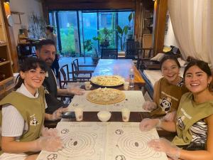 a group of people sitting around a table with a pizza at Happy Dragon Alley Hotel Beijing Tian An Men Forbidden City in Beijing +110 photos