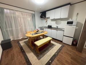 Il comprend une petite cuisine avec une table en bois et un réfrigérateur. dans l'établissement Happy Inn Kyoto えんの宿, à Kyoto 28 autres photos