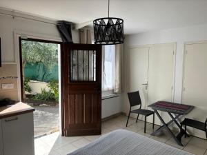 a kitchen with a door and a table with a chair at Superbe et sympa Maison in Neuilly-Plaisance