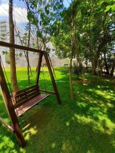 a swing in a park with green grass and trees at Park Veredas - Flat 216 in Rio Quente