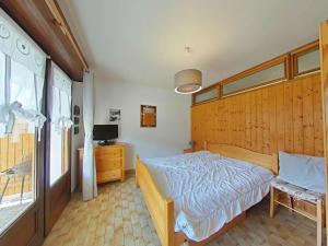 ル・グラン・ボルナンにあるAppartement 3 pièces avec garage, 6 couchages au Grand-Bornand - FR-1-241-100のベッドルーム(木製ヘッドボード、ベッド付)