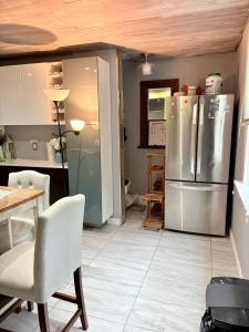 a kitchen with a refrigerator and a table and chairs at Tamira Villa in Winnipeg