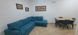 Una sala de estar con un sofá azul y una mesa. en House in Durrës, en Durrës