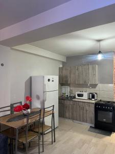 Una cocina con una mesa y un refrigerador blanco. en Stone Bazaar Apartments 3, en Skopje