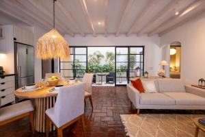 eine Küche und ein Wohnzimmer mit Tisch und Stühlen in der Unterkunft Luxury Condos I Parroquia View & Rooftop Jacuzzi I Paseo del Centro Condominio Boutique in San Miguel de Allende