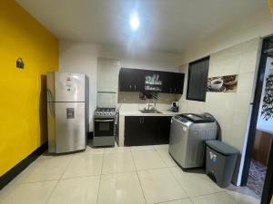 a small kitchen with a refrigerator and a sink at Lutia -Casa HD in Guaduas