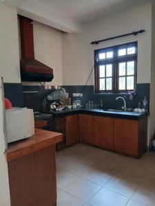 eine Küche mit Spüle und Fenster in der Unterkunft A Wood's View Villa in Kandy