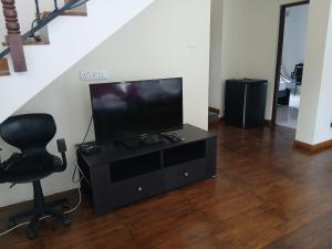 ein Wohnzimmer mit Fernseher und Sessel in der Unterkunft A Wood's View Villa in Kandy