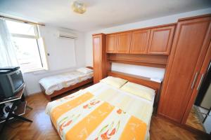 a small bedroom with a bed and a tv at Rooms Novaković in Opatija