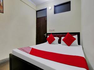 ニューデリーにあるHotel O Darshan Palaceのベッドルーム1室(大型ベッド1台、赤い枕付)
