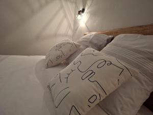a white bed with drawn pillows on it at Les Baies Roses in Bras-Panon