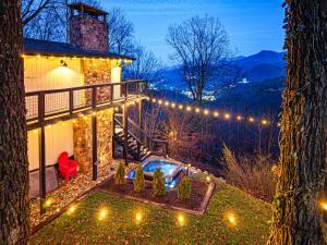 a house with a pool on the side of it with lights at Ober Lux Chalet in Gatlinburg