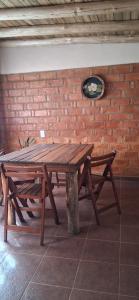 une table en bois avec un banc à côté d'un mur de briques dans l'établissement El rancho de cristina y victor, à Arroyo de Los Patos