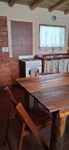 - une cuisine avec une table en bois et une cuisinière dans l'établissement El rancho de cristina y victor, à Arroyo de Los Patos