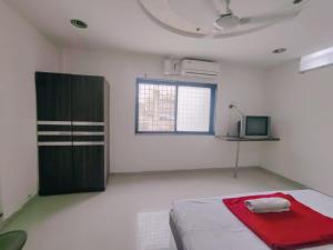 a white room with a bed and a window at Hotel Poonam Lodge in Ahmadnagar