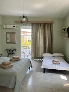 una camera con due letti e una finestra con patio di Studio Nefeli a Archangelos