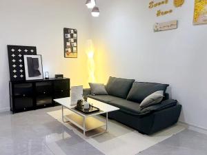 a living room with a black couch and a table at Bay Suites海景市中心 宽敞 悬空泳池 随订随住-19 in Kota Kinabalu