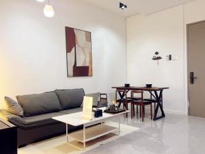 a living room with a couch and a table at Bay Suites海景市中心 宽敞 悬空泳池 随订随住-19 in Kota Kinabalu