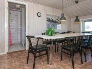 a dining room with a table and black chairs at 5 star holiday home in Ringkøbing in Ringkøbing
