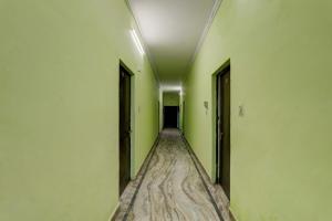 ラクナウにあるAV Hotelsの緑の壁とドアが施された空の廊下