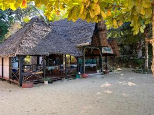 a hut with a straw roof on the beach at Lokobe eco lodge in Nosy Be