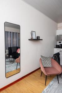 a mirror in a living room with a pink chair at D12 Premier Stay in Gaborone