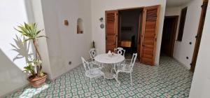 a table and chairs in a room with a plant at Case vacanza Eolie in Canneto