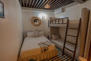 a small bedroom with a bunk bed and a ladder at Riad Qobbat Zaouïa in Fez
