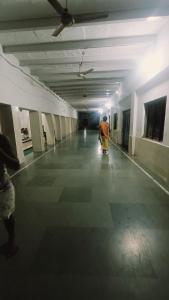 ブリンダーバンにあるvrinda hotelの建物内の長い廊下を歩いている男性