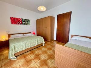a bedroom with two beds and a painting on the wall at Apartment in a residence with pool in Porto Santa Margherita di Caorle