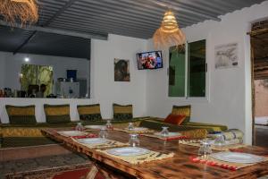 a dining room with a table and a couch at auberge Brava Tifnit 