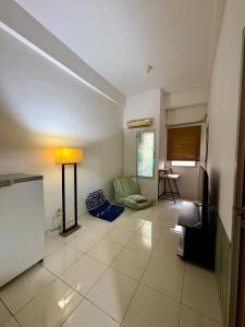 Una sala de estar con un sofá y una lámpara. en The Darmawan Room at Apartement Puncak Permai, en Mataram-baru