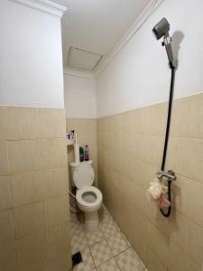 Un baño con un inodoro blanco en una habitación. en The Darmawan Room at Apartement Puncak Permai, en Mataram-baru