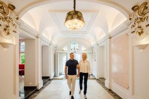 a man and a woman walking down a hallway at Hotel Josefshof am Rathaus in Vienna