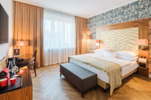 a hotel room with a bed and a desk at Hotel Josefshof am Rathaus in Vienna