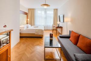 a living room with a couch and a bed at Hotel Josefshof am Rathaus in Vienna